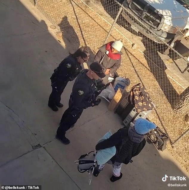 Both women are seen with police officers with their dog and belongings on the sidewalk after being led off the train in Grand Junction, Colorado on December 21.