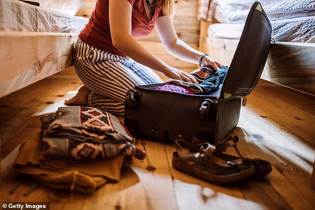 The woman explained on multiple occasions that her 55-year-old sister was packed and waiting for a 'private plane' to pick her up, but every time it was cancelled, she had to send $5,000 to help with a flight problem (STOCK IMAGE woman luggage from packaging)