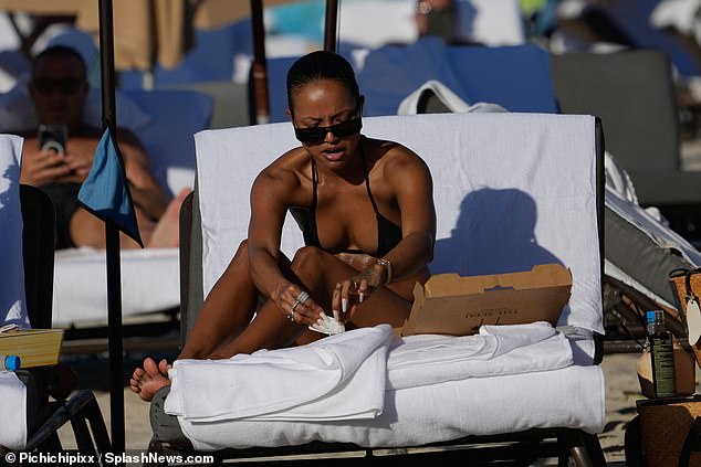 Skimpy: The 34-year-old model and actress reclined on a beach chair in a skimpy black bikini.