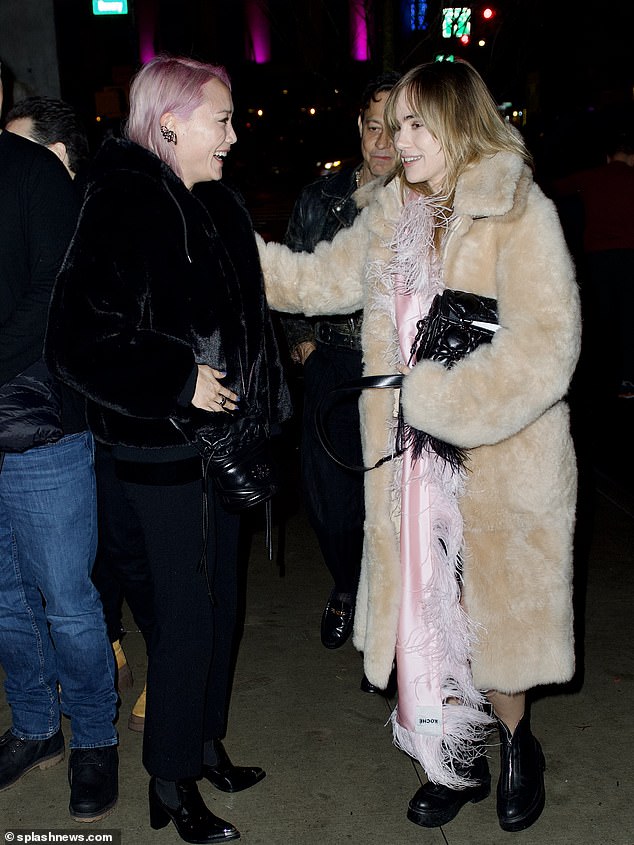 Fashionistas: Klementieff, 36, looked chic in an all-black ensemble with her hair dyed light purple, while Waterhouse went in a long, shaggy tan coat over a dress she wore with black boots and her blonde locks hairstyles far beyond her.  back