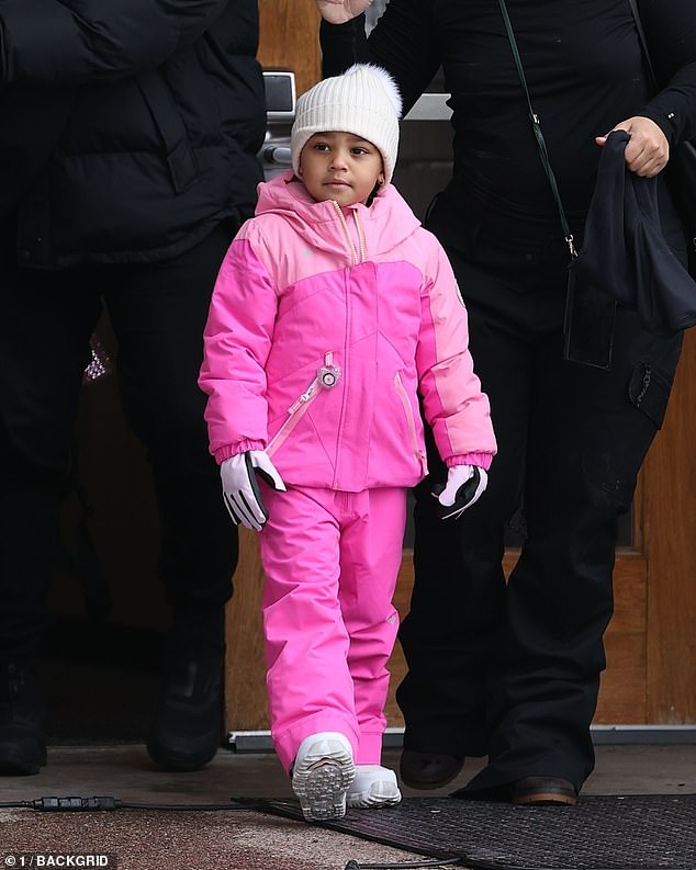 Miniature Fashion: Stormi wore a white ribbed hat with a pom pom on top, matching her white snow boots