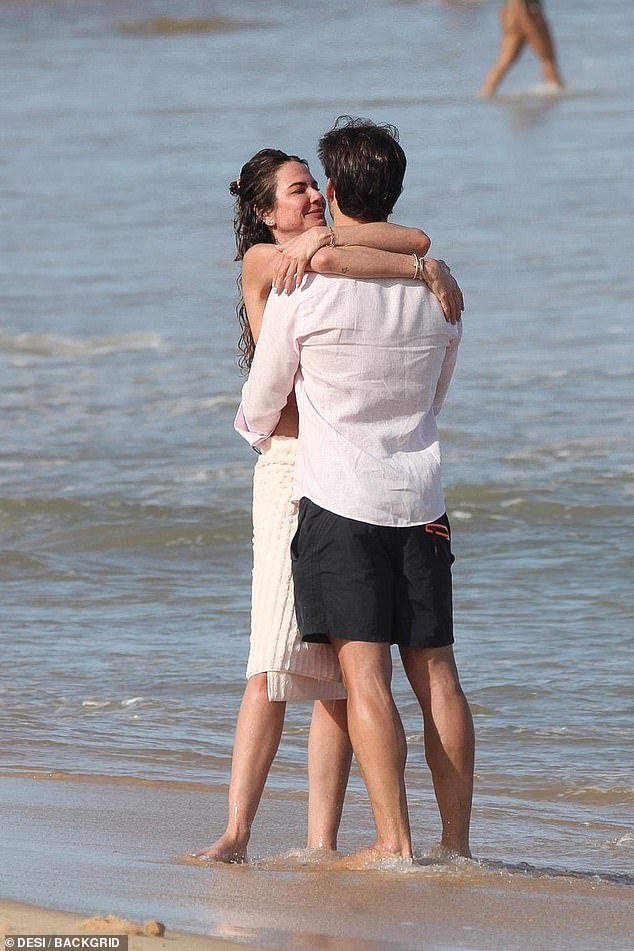 In love: The mother of two couldn't keep her hands off her man as they hugged and kissed while frolicking on the shore