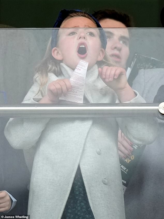 Eight-year-old Mia, dressed in a gray coat with brown boots, clings tightly to a piece of paper as she screams towards the racecourse in footage from the start.