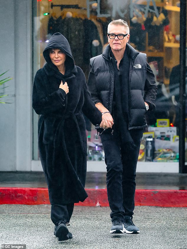 Hand in hand: The reality show host, 59, and the Clash of the Titans actor, 71, who recently underwent shoulder surgery, held hands as they maneuvered through puddles on the street