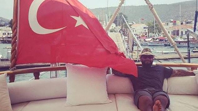 Duax Ngakuru in a rare photograph is seen relaxing on a yacht next to a Turkish flag