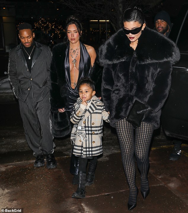 Warm: The adorable girl was bundled up in a cream and black wool coat and black boots when she arrived at the celebration with Kylie, 25, and Stassie, 25, and family friend Carter Gregory, 29