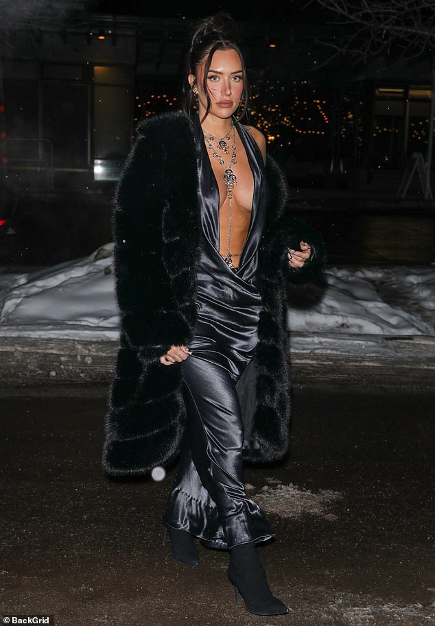 Plunging: Stassie stepped out of the van in a dark gray satin halter dress that plunged to her navy