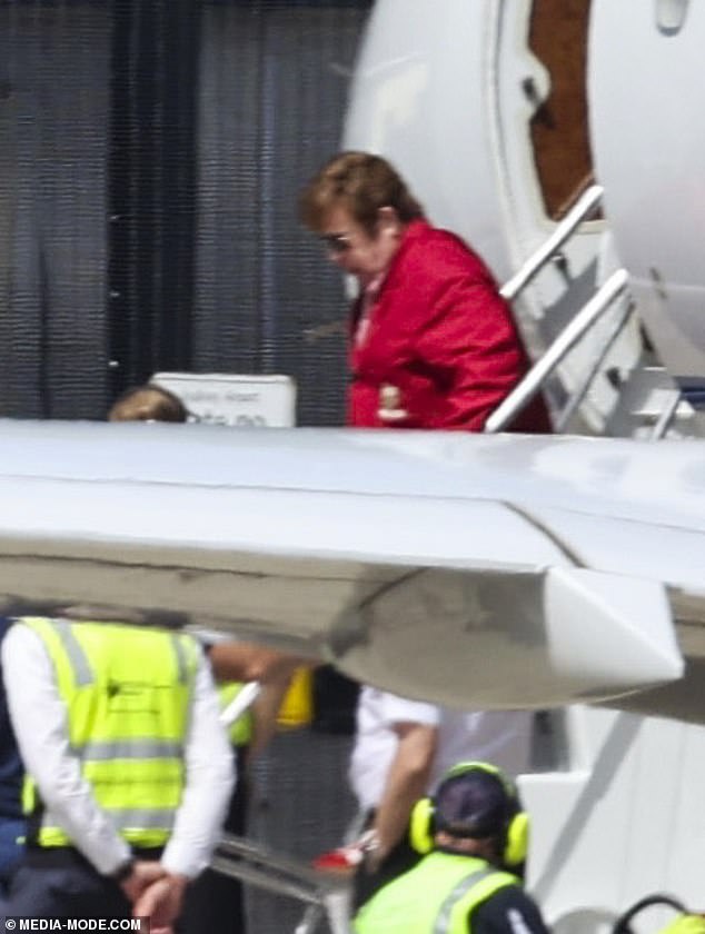 The 75-year-old British singer was wearing a bright red jacket and blue shorts when he got off the plane.