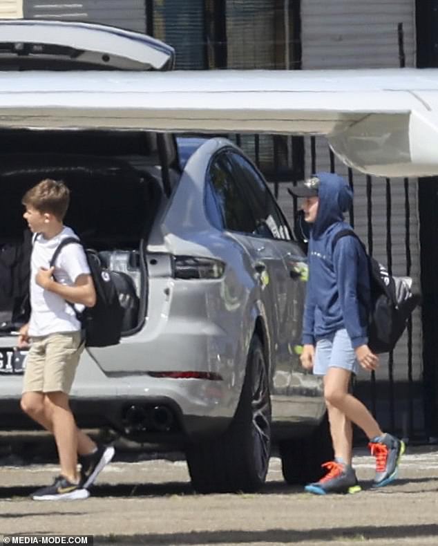 Meanwhile, Elton's sons Zachary and Elijah held their backpacks as they walked to the vehicle.