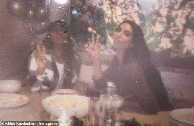 Hot sisters: Khloe shared a picture of her sister, Kim, wearing her dark hair down her back and flashing a peace sign