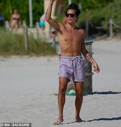 Playtime: Other friends joined Rudy for a game of paddle tennis in the sand.