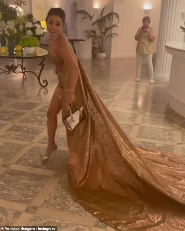 Golden girl: Hudgens shared a humorous clip in which she was strutting around a hotel lobby in high heels and commenting that she was helping to clean the floors with her long tail dragging behind her