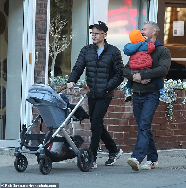 Pushing his son: Cooper pushed his newborn son Sebastian in a large gray stroller as they walked down the street.