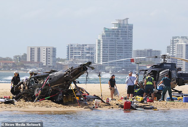 The two helicopters involved in the collision are seen on the sandbar on the Gold Coast in Queensland.