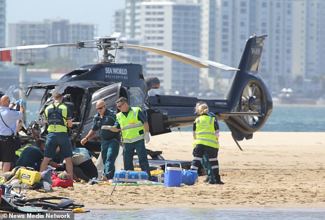 Rescue workers are shown at the scene of a helicopter crash over the Broadwater estuary on the Gold Coast.