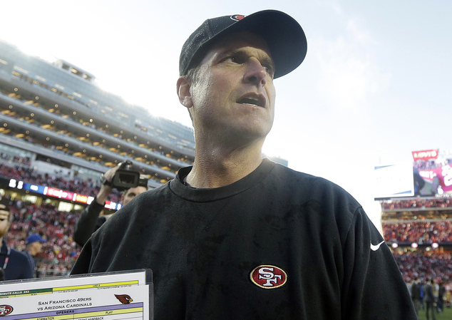 Jim Harbaugh walks off the field after an NFL football game against the Arizona Cardinals