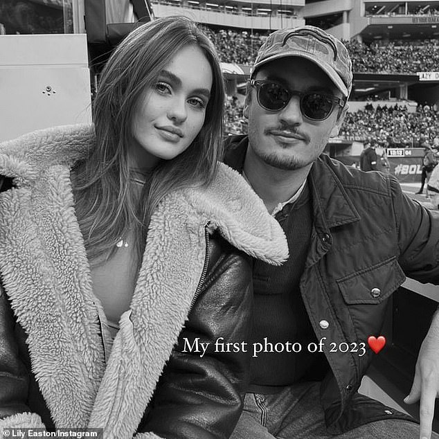 Stunner: The 'golfer/investor/producer,' as he describes himself in his Instagram bio, brought his stunning girlfriend Lily Easton, 22, to the game.  Lily posted a sweet couple photo on Instagram, captioned: 'My first photo of 2023'