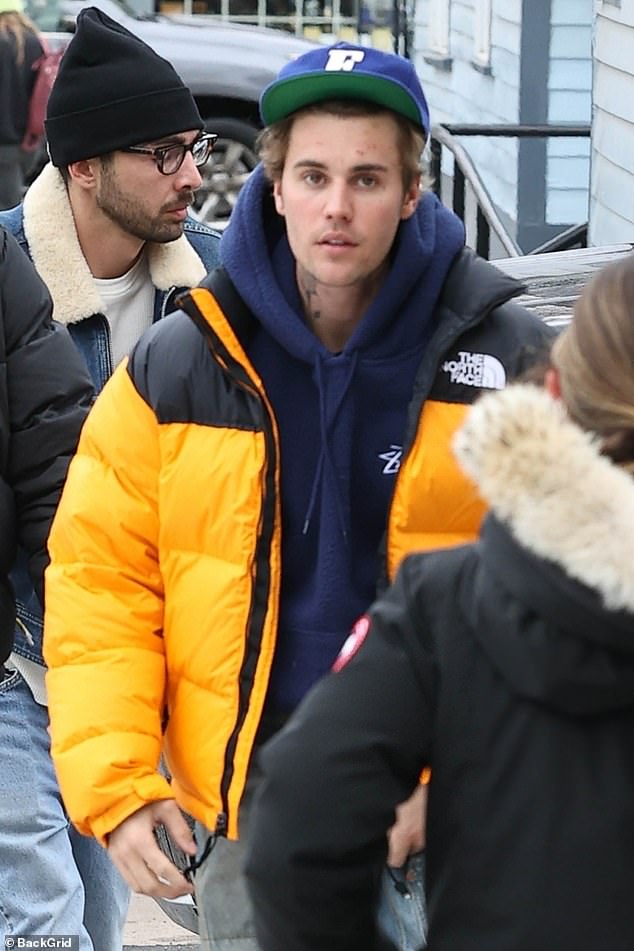 Laid back: Justin, 28, meanwhile, stood out in a bright yellow coat he wore over a navy blue hoodie