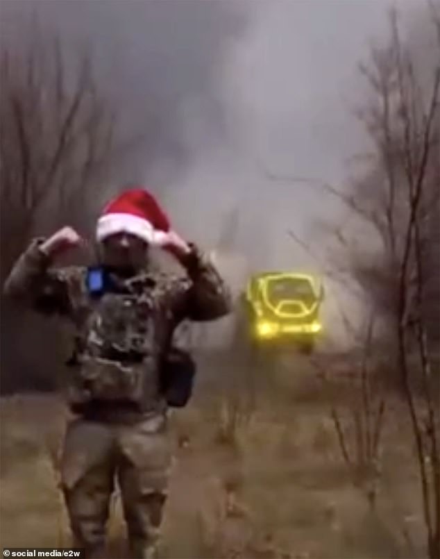 Pictured: Video from elsewhere shows a Ukrainian soldier wearing a festive Santa hat as a HIMAR missile is launched at the time of the Makiivka attack.  The HIMAR rocket system behind it has been decorated with Christmas lights.