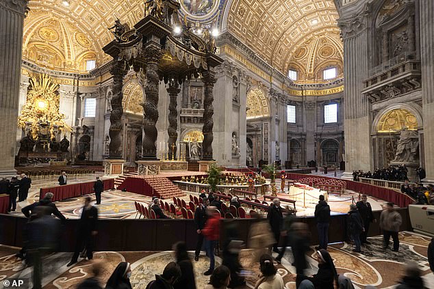 People inside St. Peter's Basilica looking at the body of Pope Benedict XVI, who died at 9:34 a.m. Saturday.