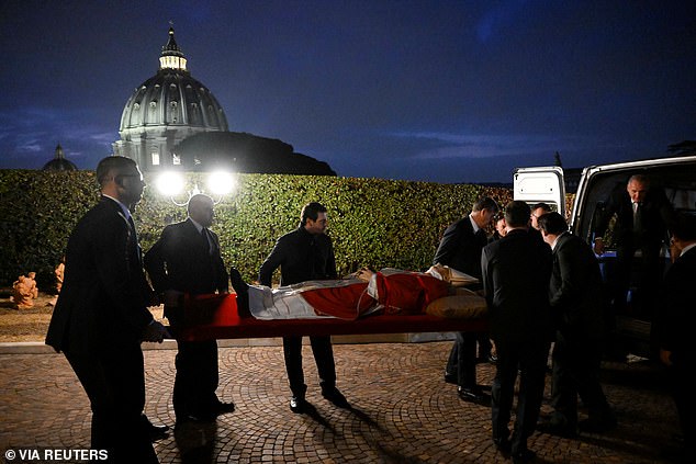 The body of Pope Benedict being transported to the basilica in preparation for the three days of his laying in