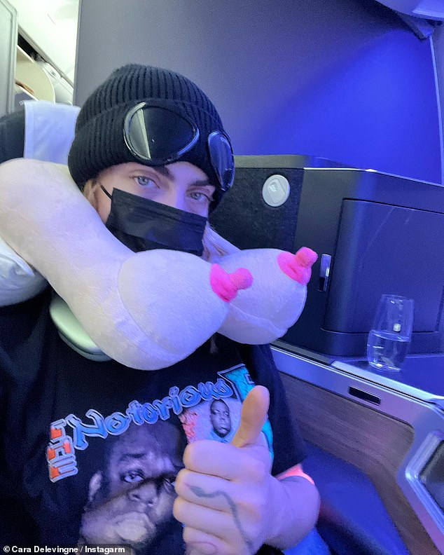 Chest is the best: A second image showed her sitting in first class on a plane while wearing a Notorious BIG T-shirt and a Covid mask