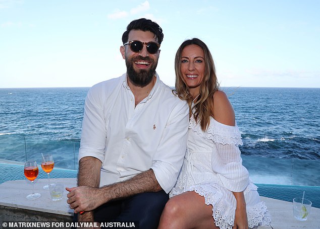 A couple enjoy drinks by the sea at a stunning Sydney mansion on New Year's Day