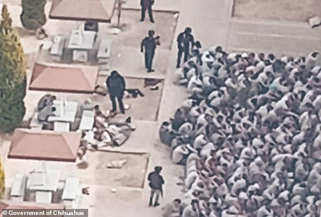 Inmates are surrounded and seated together outside Cereso State Prison No. 3 moments after security forces regained control of the penitentiary.