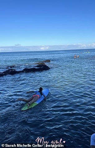 Doting Mom – The proud mom made sure to include her daughter, opting to show her lying on a surfboard in the sea with the water rippling around her.