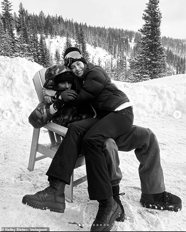 In love: In one photo, Hailey hugged her husband Justin as he sat on his lap on the snowy mountain