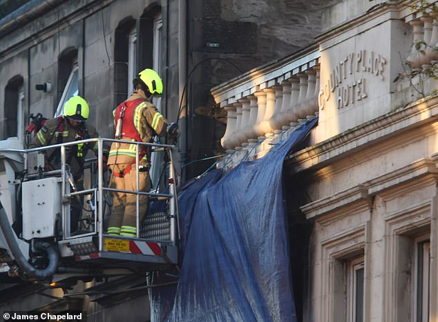 Firefighters continue to work outside the hotel after three people died in a fire at dawn