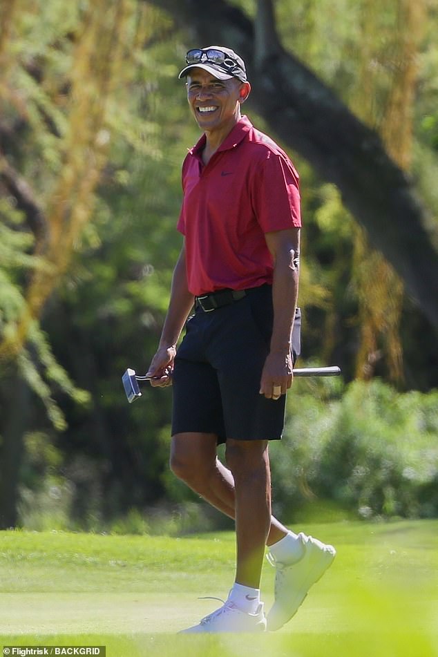 Barack donned a cap and glasses which he paired with a red polo shirt and shorts as he cut a casual figure on the court.