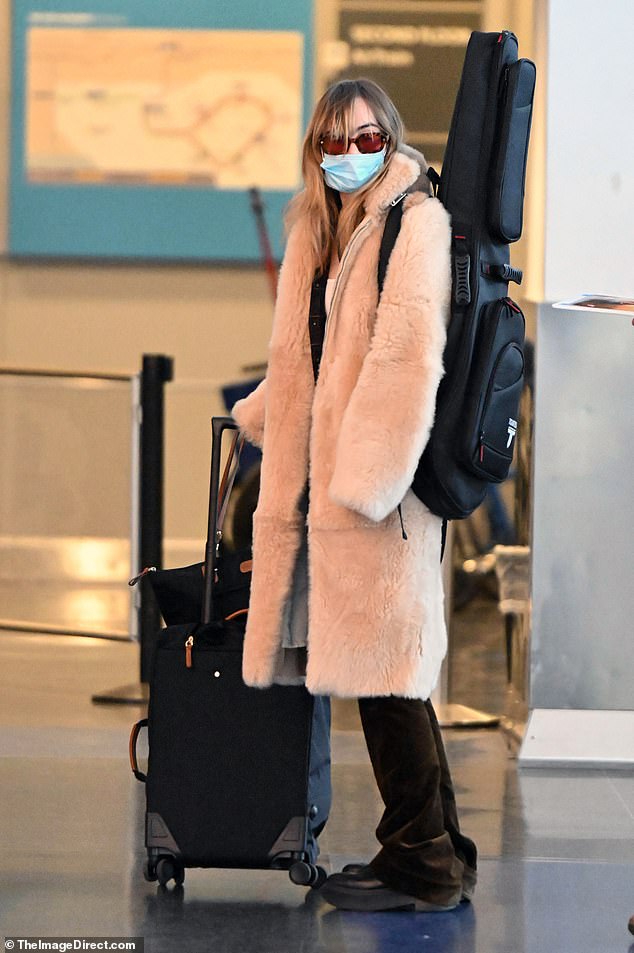 Cozy: Robert, 36, and Suki, 30, coordinated in neutral colors while walking through the airport.