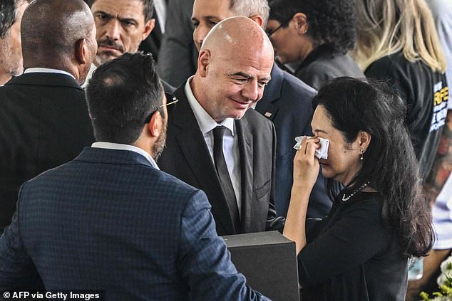 Standing near the coffin, Infantino was also seen comforting Pele's widow Marcia Aoki (right) and her son Edinho while shaking hands with others under the awning.