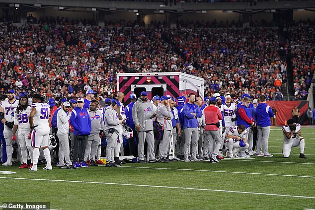 The players stand around the ambulance in which Hamlin was being treated.