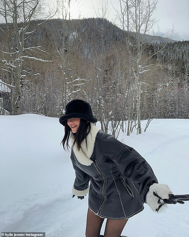 Goofing around: Kylie appeared to be enjoying herself in another photo that showed her in a fleece-lined black leather coat in the snow