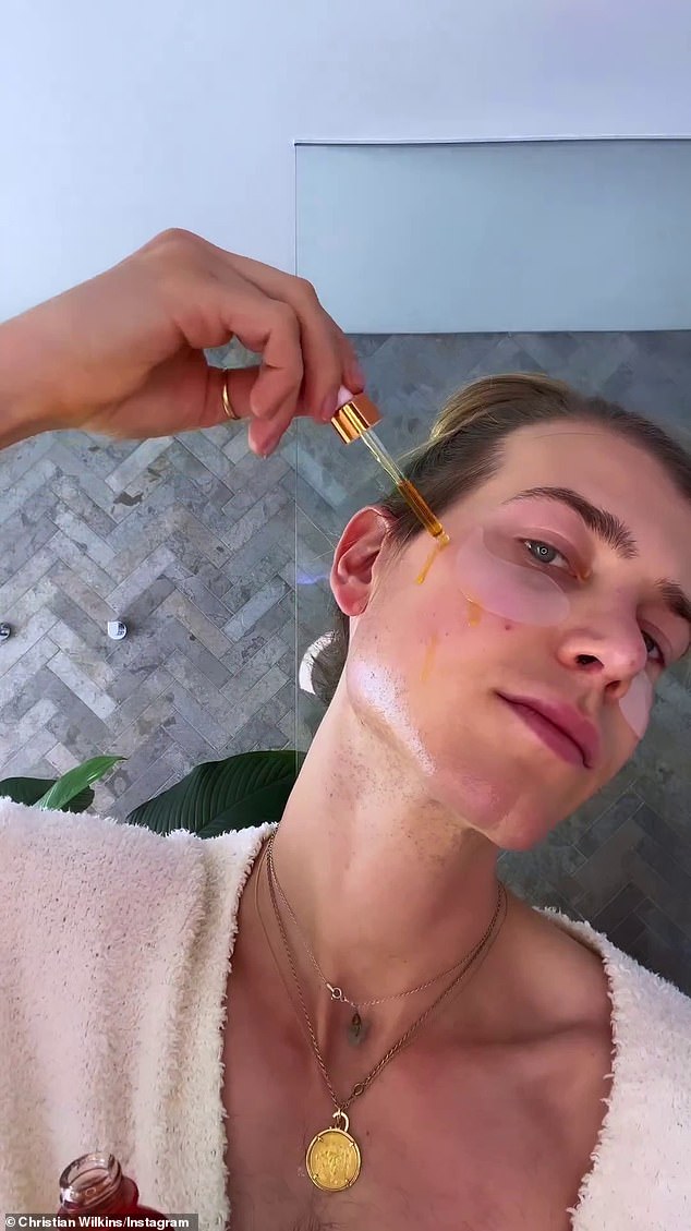 Christian applies serums to his face while wearing gel patches under his eyes.