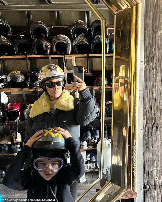 Coincidence: Kourtney shared another snapshot with one of her children.  They matched black leather jackets with crash helmets on their heads.