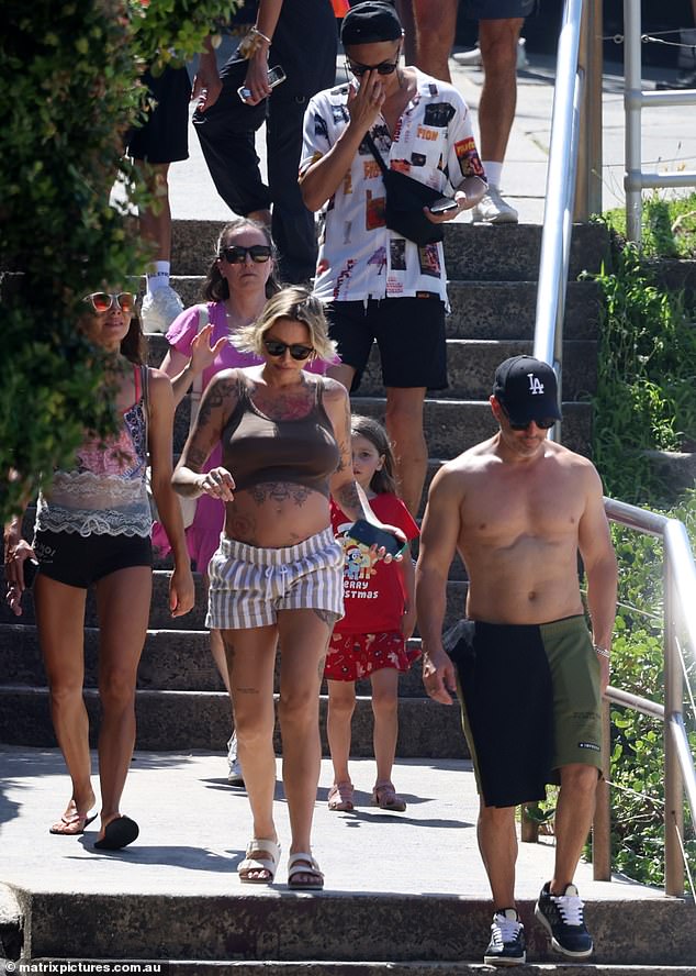 Jason's brother, Brett, also joined the group and opted for green shorts and a black T-shirt before removing it.