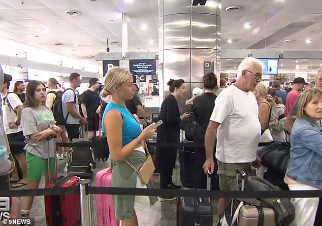 Passengers (above) are seen waiting at Melbourne airport after their flight to Bali went upside down following a paperwork error