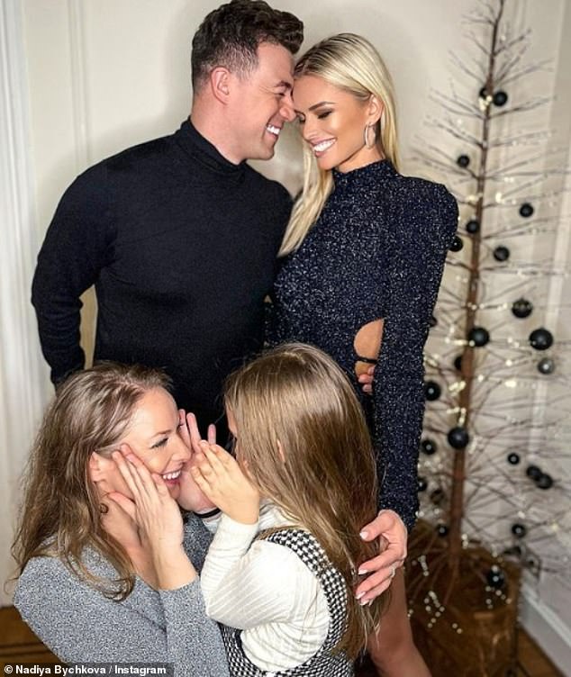 So sweet: The professional dancing couple couldn't contain their smiles as they wrapped their hands around Nadiya's six-year-old daughter Mila as they enjoyed the festive season in Belgium