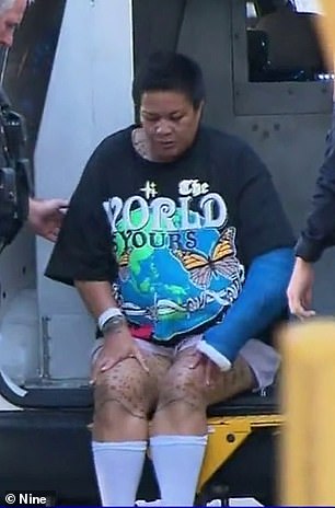 Taufua was seen wearing a hospital wrist brace, compression socks and a cast as she was escorted to the guardhouse Tuesday afternoon (above).