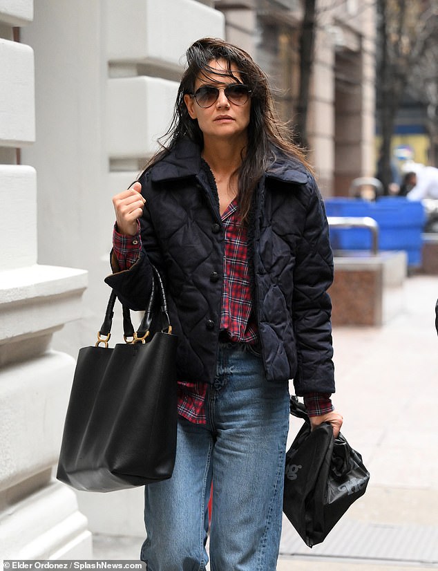 Hands full: Katie, who wore aviator glasses over her makeup-free complexion, also carried a large black leather handbag and a black shopping bag during her outing