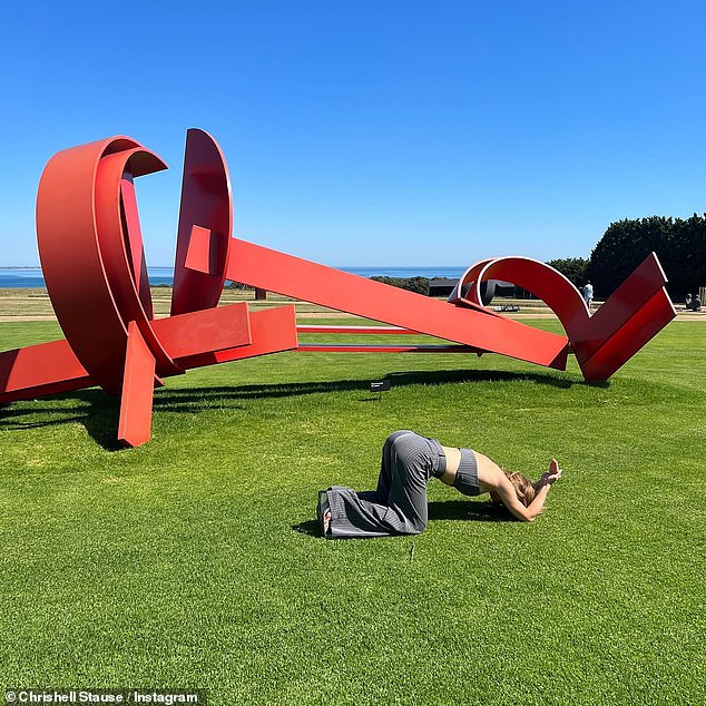 One with nature: Chrishell crouched in the grass while wearing a matching top and pants set from Jagger and Stone