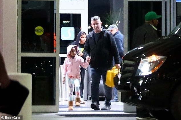 Twin: A silver-haired staff member was holding the hand of the hip-hop power couple's five-year-old daughter, Rumi Carter, who was sporting a pink hoodie with Ugg boots.