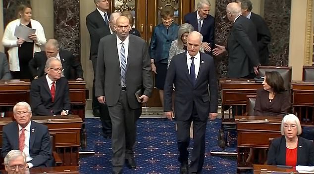 John Fetterman (left) walked into the Senate chamber Tuesday alongside Pennsylvania's other Democratic Sen. Bob Casey (right)