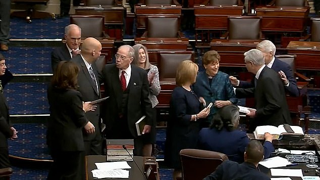 Sen. John Fetterman talks with Sen. Chuck Grassley, a Republican from Iowa, on the Senate floor Tuesday after being sworn-in by Vice President Kamala Harris, the president of the Senate