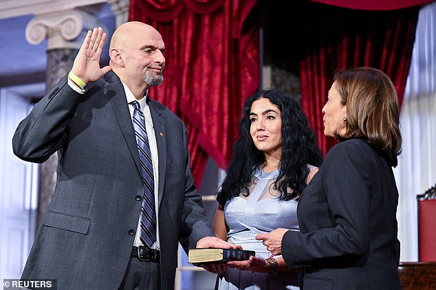 Sen. John Fetterman (left) retakes the oath at a ceremonial swearing-in with wife Gisele (center) holding the Bible with Vice President Kamala Harris (right)