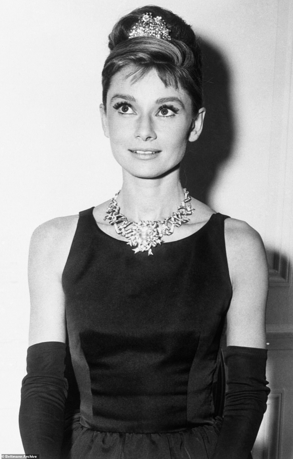 Casey's slicked-back hair is similar to Audrey's favorite hairstyle (pictured around 1960 when filming for Breakfast at Tiffany's began) and the dress's silhouette is cinched to flatter her waist.