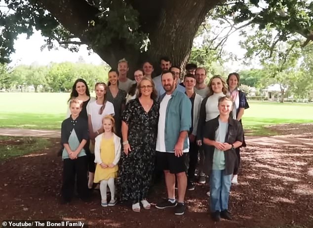 Jeni (pictured center left with her husband and children) has made a name for herself online sharing her life with 16 children ages seven to 32, nine of whom still live at home.